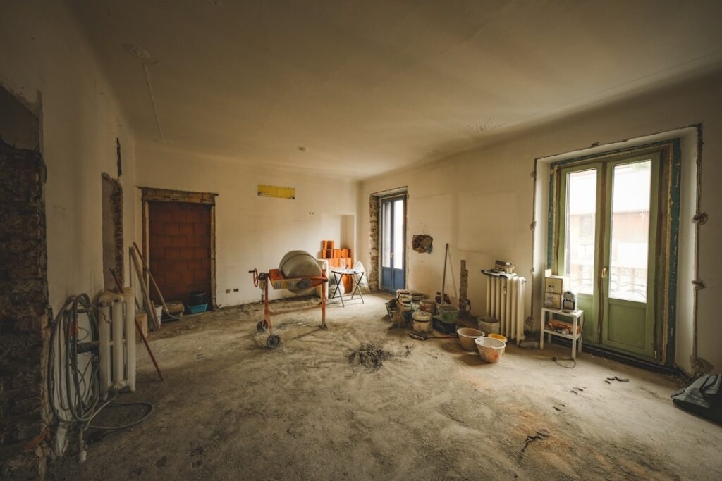 Construction materials and tools scattered across a room under renovation.